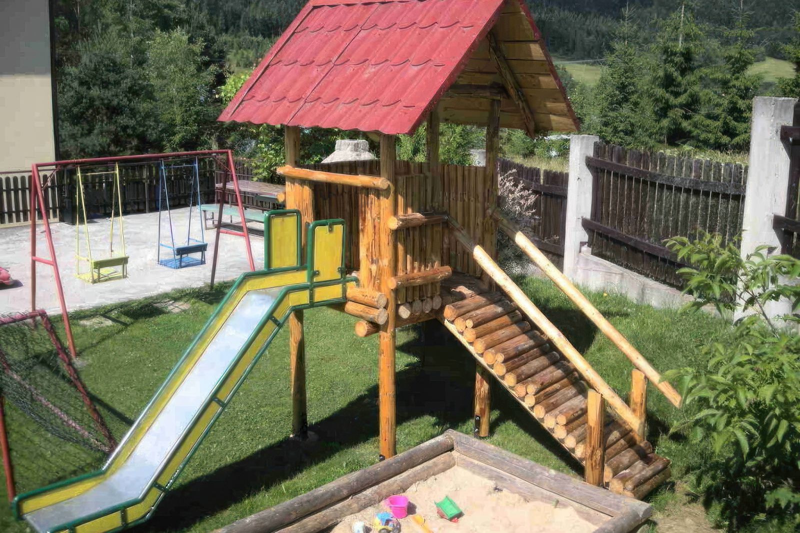 Plac zabaw Willi OdNova w Tyliczu z drewnianą zjeżdżalnią, huśtawkami, widok na Beskid